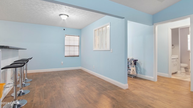 interior space with a textured ceiling and hardwood / wood-style floors