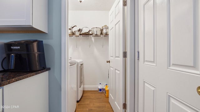 clothes washing area featuring light wood-type flooring and washing machine and clothes dryer