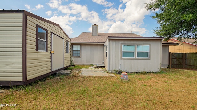 rear view of house featuring a yard