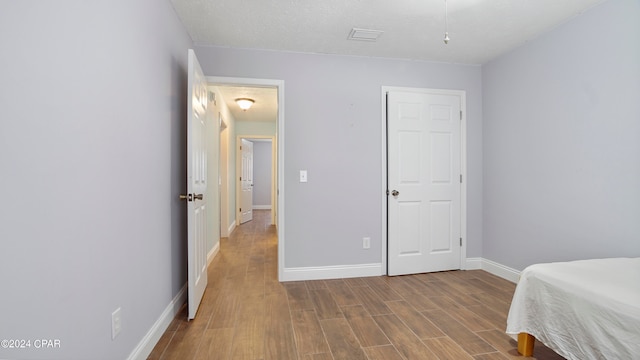 bedroom featuring a textured ceiling and hardwood / wood-style floors