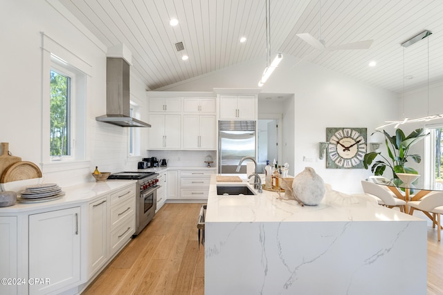 7507 Loons Call Ln, Panama City Beach, FL 32413 - kitchen featuring light wood-style flooring, wall chimney exhaust hood, a sink, and high quality appliances
