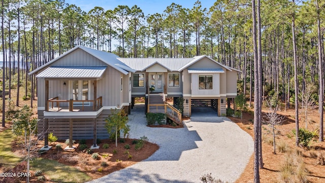 7507 Loons Call Ln, Panama City Beach, FL 32413 - view of front facade with a carport, metal roof, covered porch, stairway, and gravel driveway