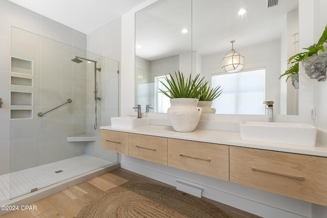 bathroom with a tile shower, vanity, and hardwood / wood-style floors