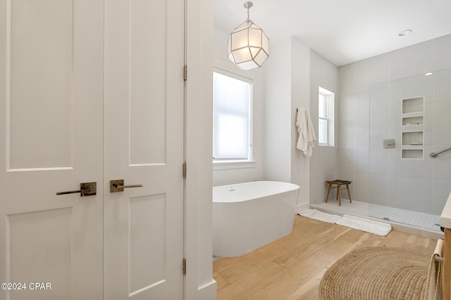 bathroom featuring wood-type flooring, separate shower and tub, and vanity