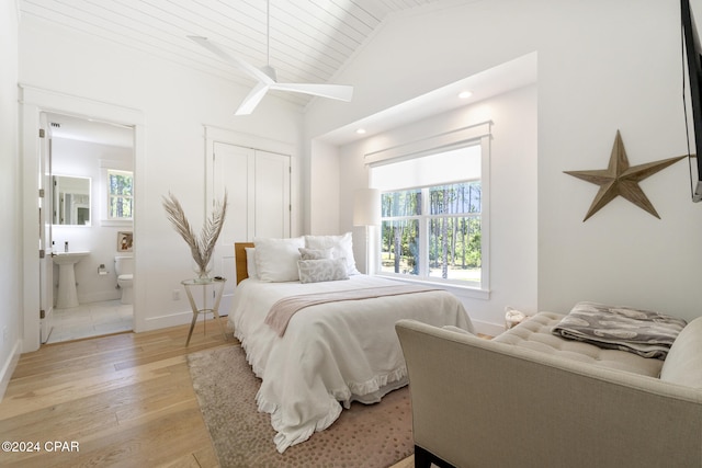 tiled bedroom featuring lofted ceiling and ensuite bathroom