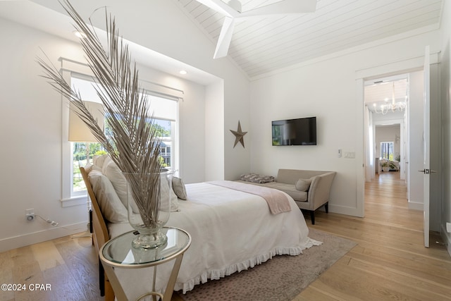 bedroom with ceiling fan with notable chandelier, high vaulted ceiling, and light hardwood / wood-style floors