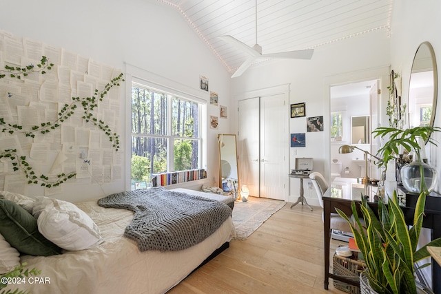 bedroom with light wood-type flooring, high vaulted ceiling, ceiling fan, and a closet