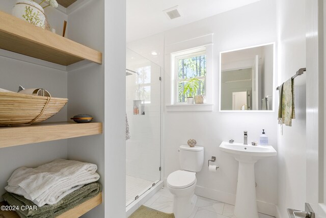 bathroom with toilet, a shower with door, and tile patterned floors