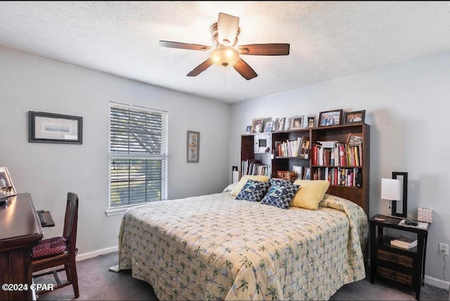 bedroom with a textured ceiling, ceiling fan, and dark colored carpet