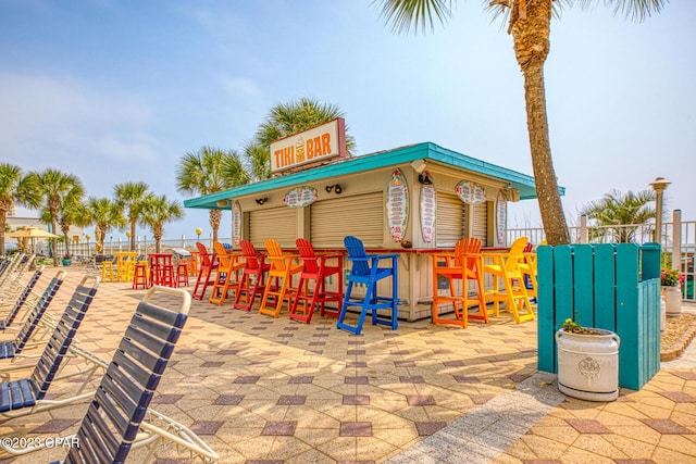 view of playground featuring a patio and exterior bar