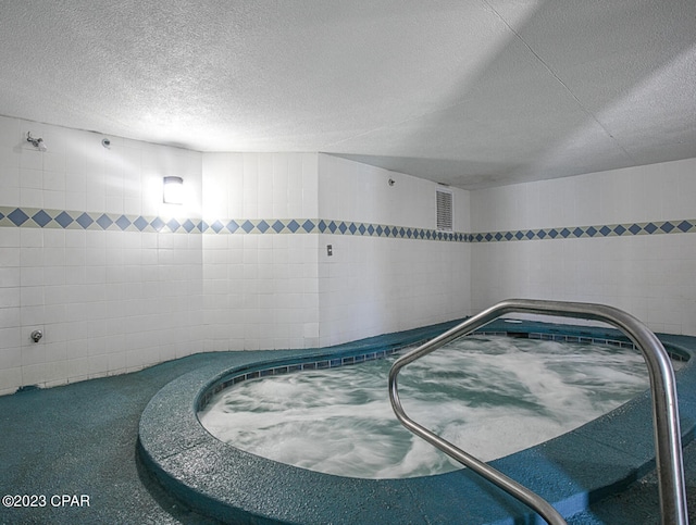 interior space featuring a textured ceiling and tile walls