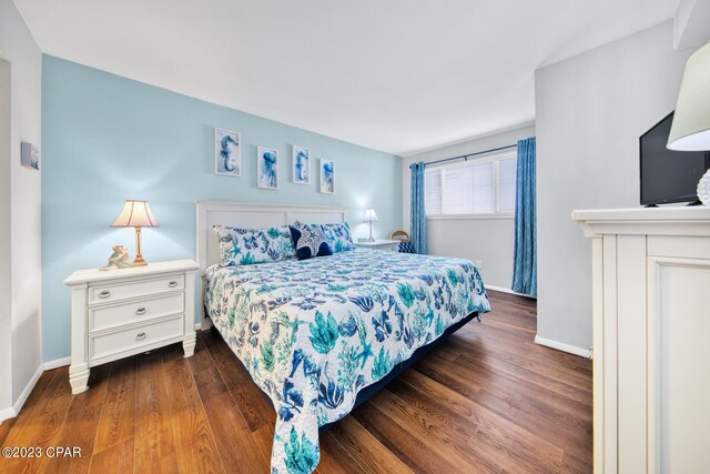 bedroom with dark hardwood / wood-style flooring