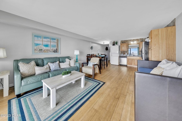 living room with light hardwood / wood-style flooring and sink