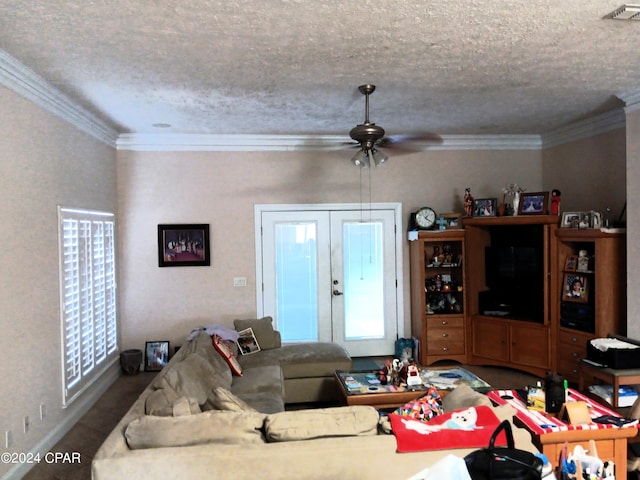 living room featuring ceiling fan, ornamental molding, and a textured ceiling