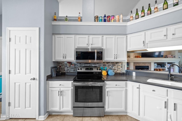 kitchen with white cabinetry, light tile patterned flooring, and stainless steel appliances