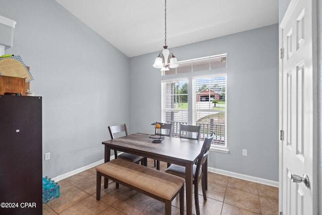 dining room featuring tile patterned floors, lofted ceiling, and a chandelier