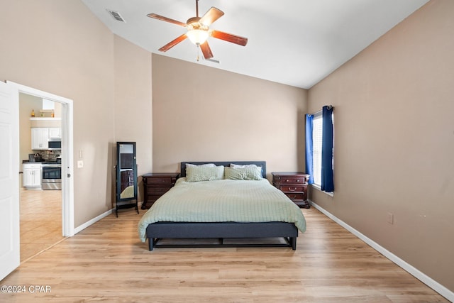 bedroom with ceiling fan, light hardwood / wood-style floors, and vaulted ceiling