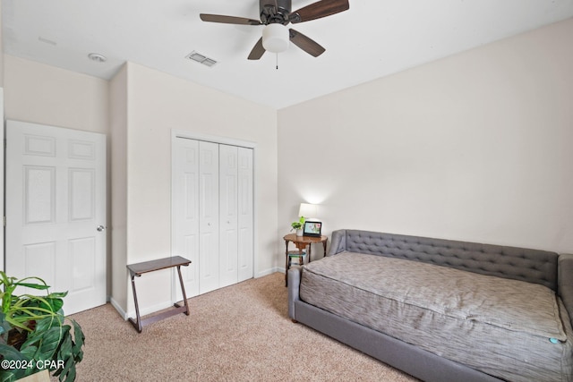 bedroom featuring ceiling fan, a closet, and light carpet