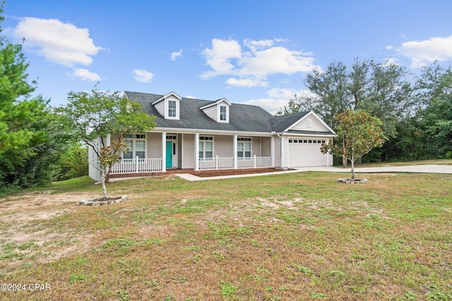 view of front of property with covered porch, a garage, and a front lawn