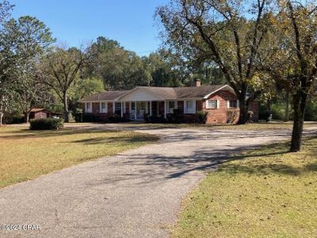 single story home featuring a front lawn