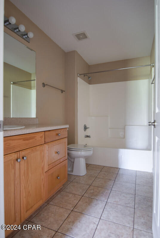 full bathroom featuring shower / bath combination, vanity, toilet, and tile patterned flooring