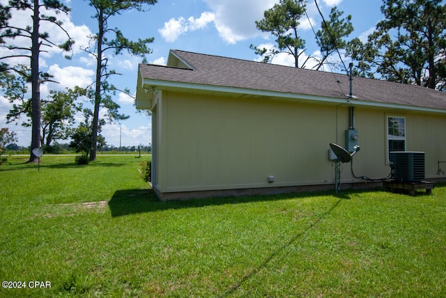 view of side of home with cooling unit and a lawn