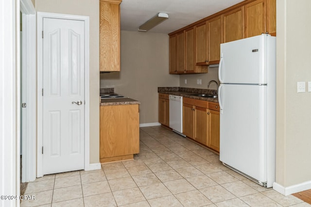 kitchen featuring sink, white appliances, and light tile patterned flooring