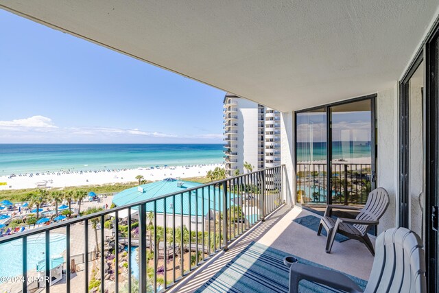 balcony featuring a beach view and a water view