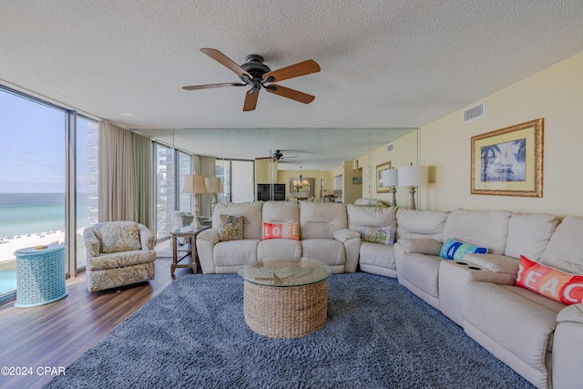 living room with a wall of windows, visible vents, plenty of natural light, and wood finished floors