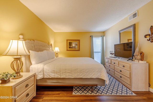 bedroom with dark wood-style flooring and visible vents