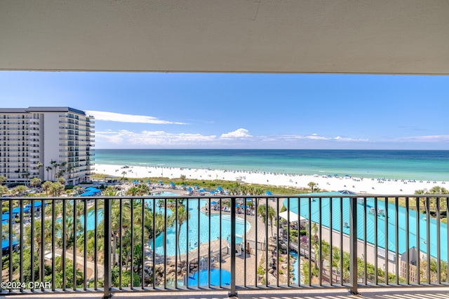 balcony with a water view and a view of the beach