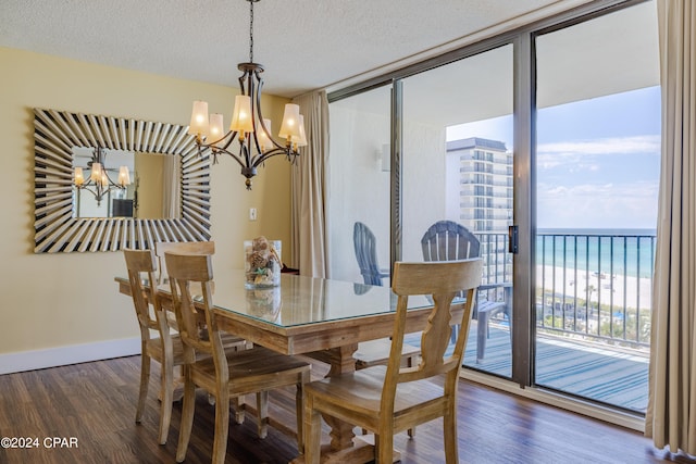 dining space with wood finished floors, floor to ceiling windows, a textured ceiling, and an inviting chandelier