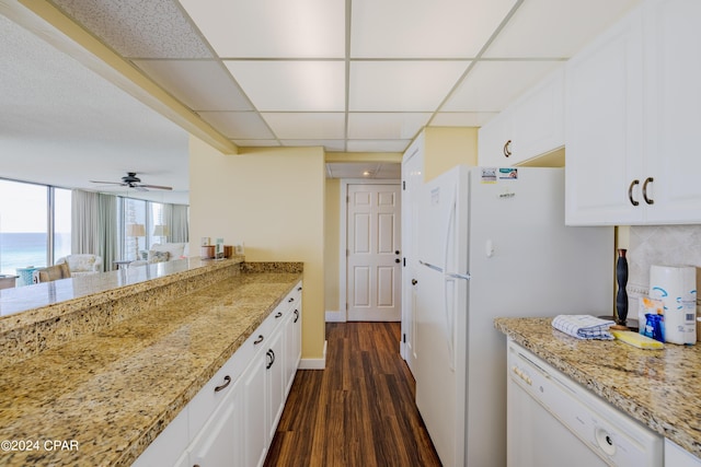 kitchen with white appliances, white cabinetry, a drop ceiling, and dark wood-type flooring