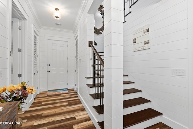 entryway with dark wood-type flooring and crown molding