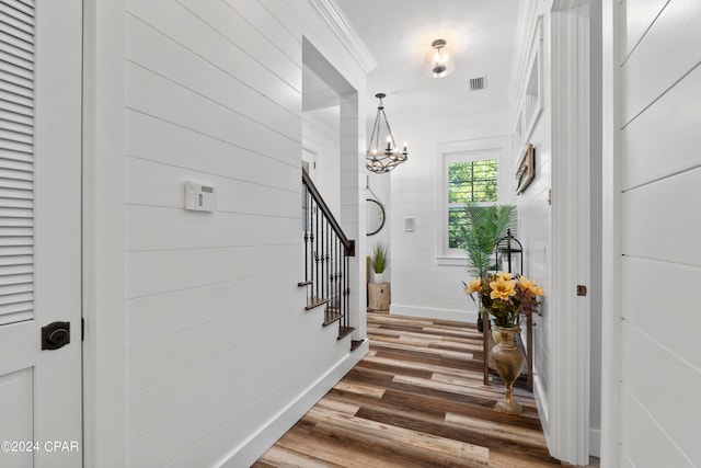 interior space featuring an inviting chandelier, crown molding, and hardwood / wood-style floors