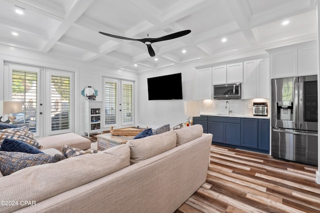 living room with beamed ceiling, ceiling fan, light hardwood / wood-style flooring, ornamental molding, and sink