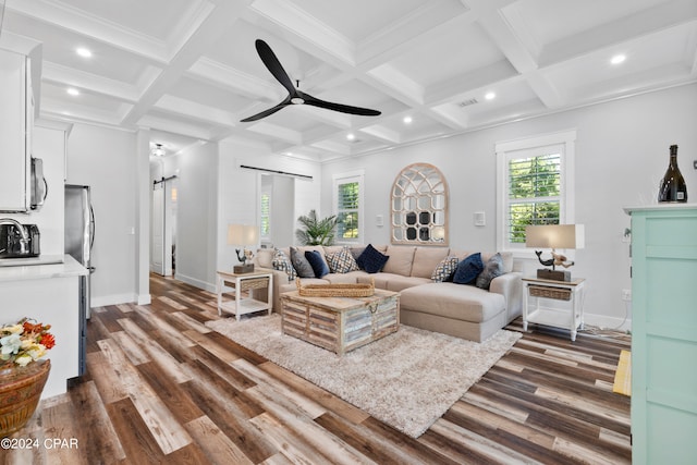 living room featuring coffered ceiling, dark wood-type flooring, a barn door, beamed ceiling, and ceiling fan