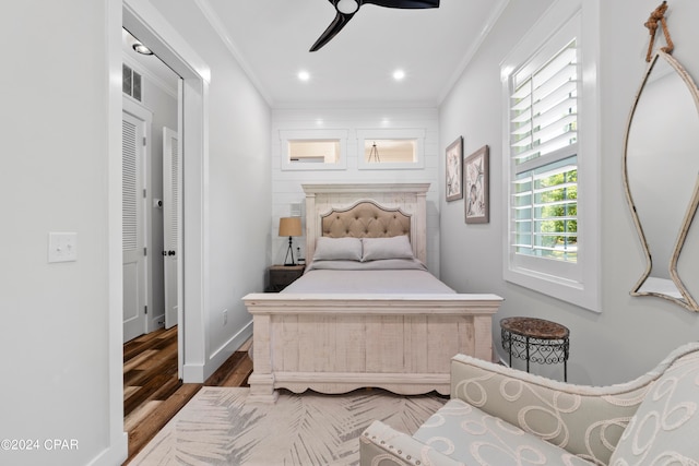 bedroom with ceiling fan, ornamental molding, and hardwood / wood-style floors