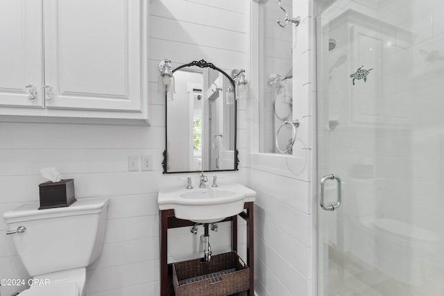 bathroom featuring toilet and a shower with shower door