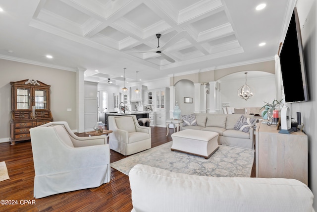 living room with ceiling fan with notable chandelier, coffered ceiling, ornamental molding, and dark hardwood / wood-style flooring