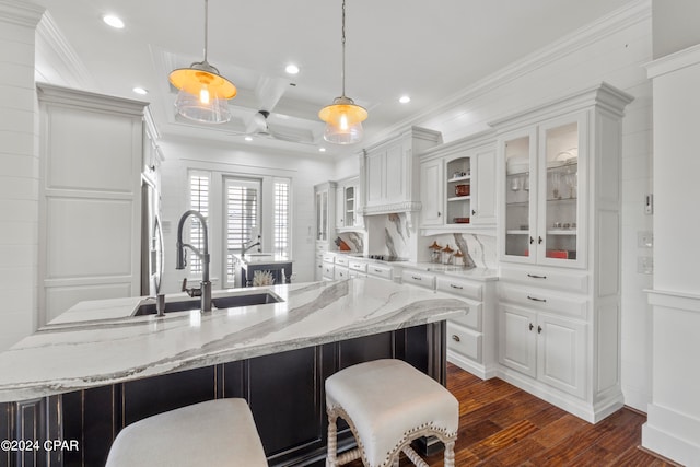 kitchen featuring pendant lighting, light stone counters, beamed ceiling, dark wood-type flooring, and white cabinets