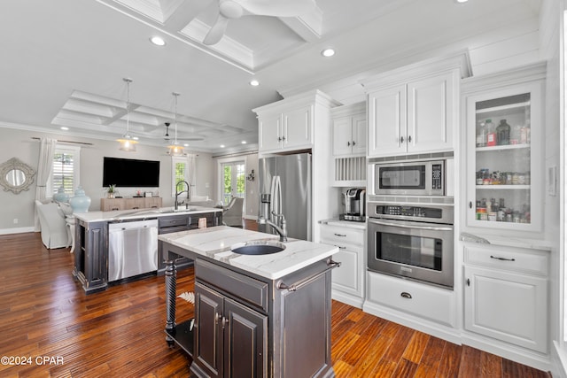 kitchen featuring appliances with stainless steel finishes, a center island with sink, ceiling fan, and white cabinets