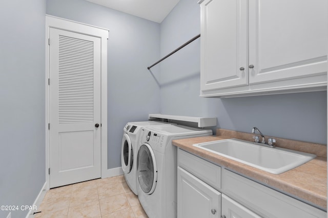 laundry area with light tile patterned floors, cabinets, sink, and washer and dryer