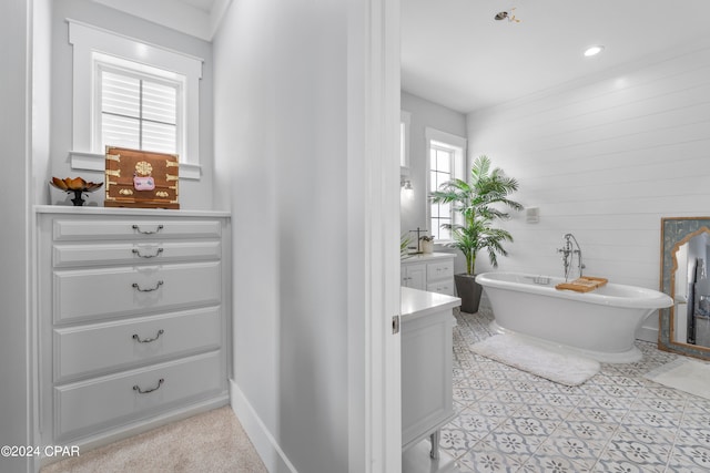 bathroom featuring vanity, tile patterned flooring, plenty of natural light, and a washtub