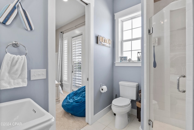 bathroom featuring plenty of natural light, toilet, and a shower with door