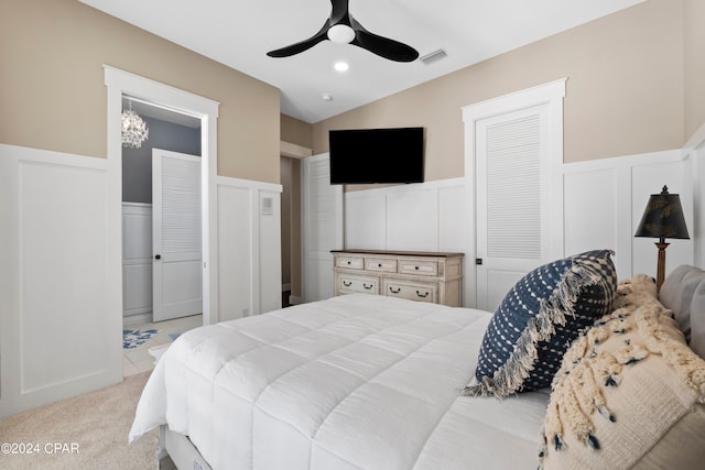 bedroom featuring two closets, ceiling fan, and light colored carpet