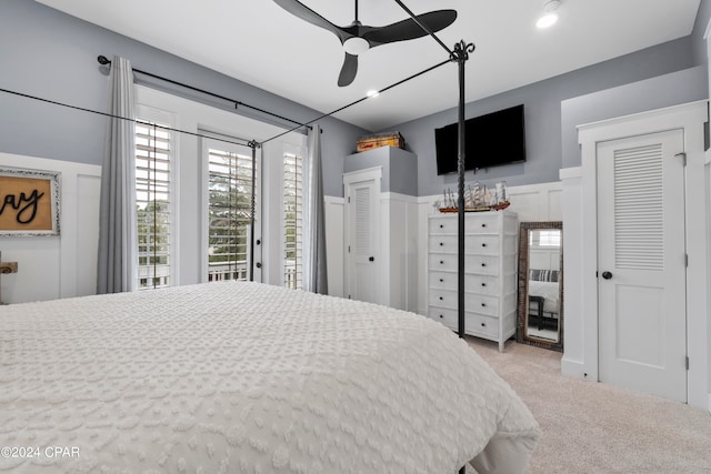 bedroom with ceiling fan, light carpet, access to exterior, and multiple windows