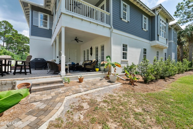 back of property featuring ceiling fan, a balcony, outdoor lounge area, and a patio