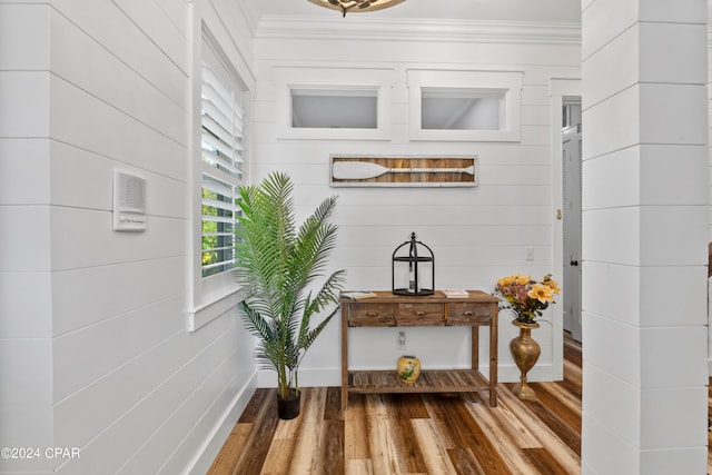 interior space featuring wood-type flooring and ornamental molding