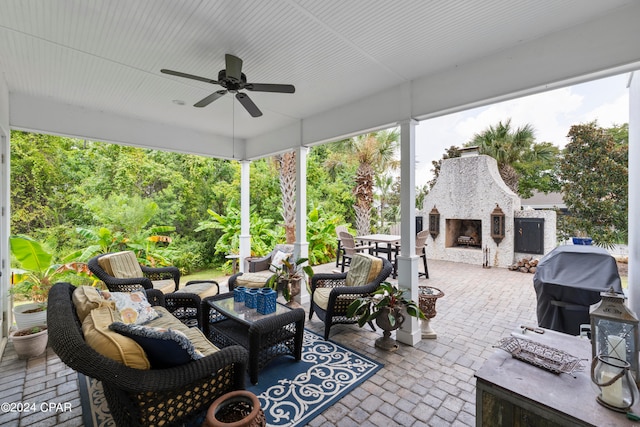 view of patio featuring an outdoor living space with a fireplace, area for grilling, and ceiling fan